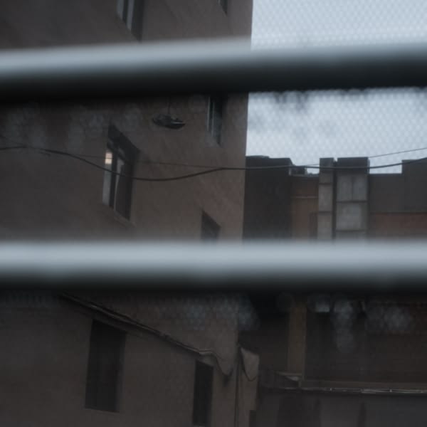 A view of a building through a metal fence.