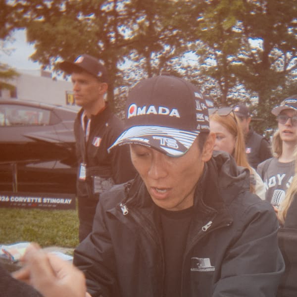 A man wearing a black hat with the word "Mada" on it.