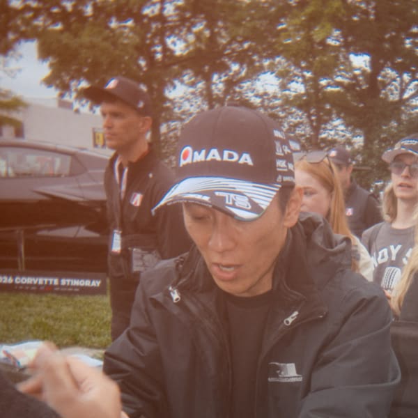 A man wearing a black hat with the word "Mada" on it.