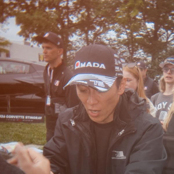 A man wearing a black hat with the word "Mada" on it.
