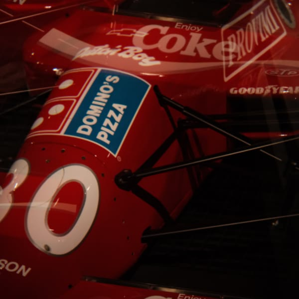 A red and white racing car with a Coca Cola advertisement.