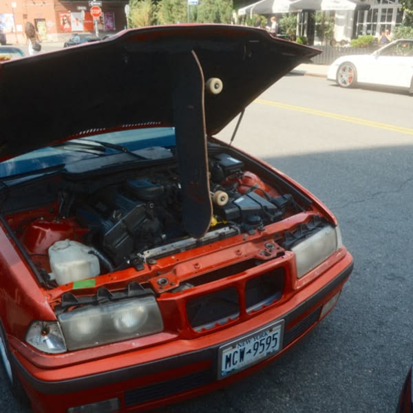 A red car with the hood open.