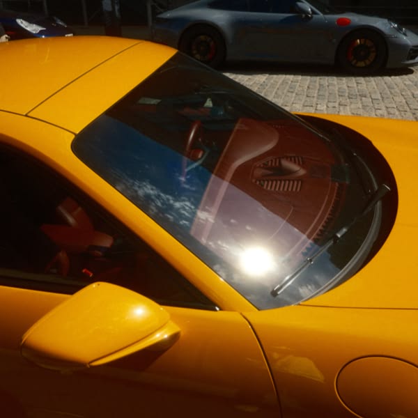 A yellow sports car with a red interior.