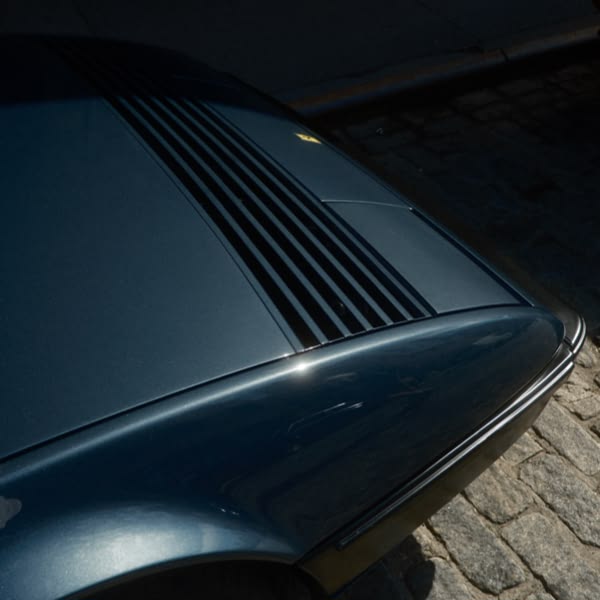 A blue car with a yellow stripe on the side.