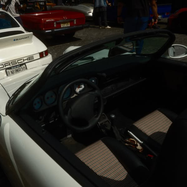 A white convertible sports car with a black top.