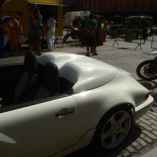 A white convertible car with a black top.