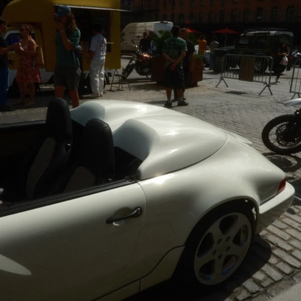 A white convertible car with a black top.