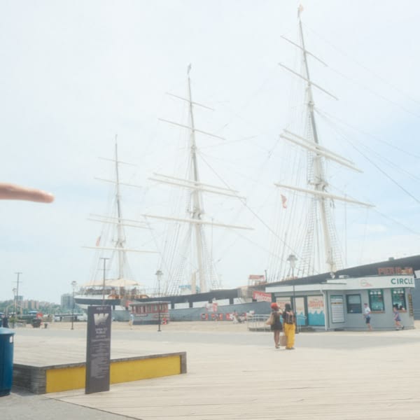 A wooden pier with a sign in front of it.