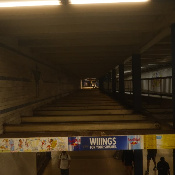 A sign for wings is hanging from the ceiling.