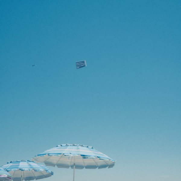 A blue and white umbrella in the sand.
