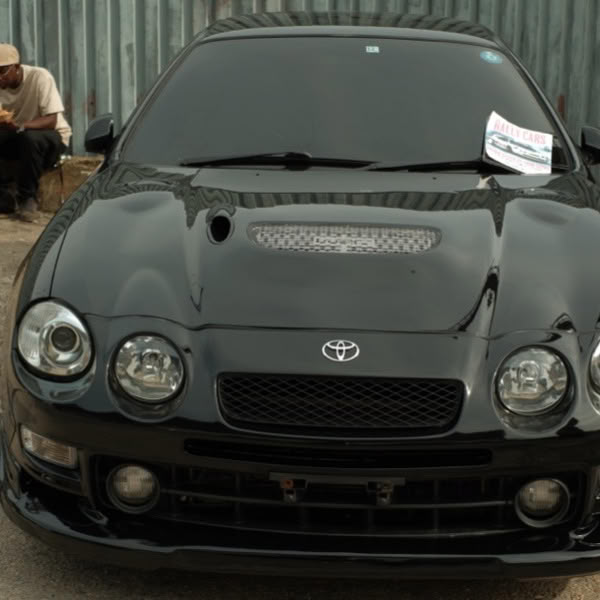 A black car with a paper on the hood.